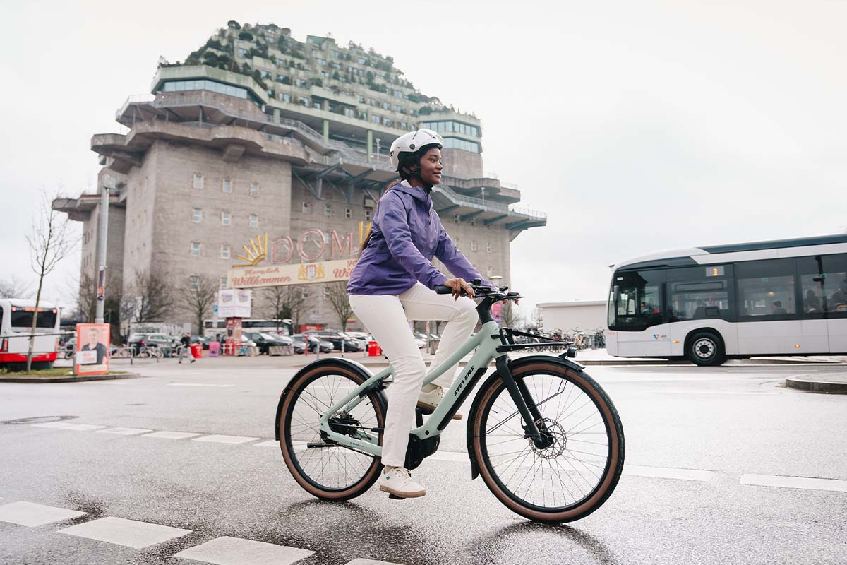 Frau fährt mit einem E-Bike durch eine städtische Gegend