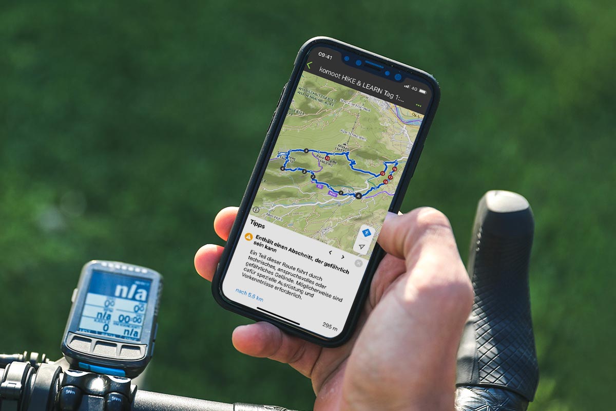 In der Hand gehaltenes Smartphone mit geöffneter Komoot App.