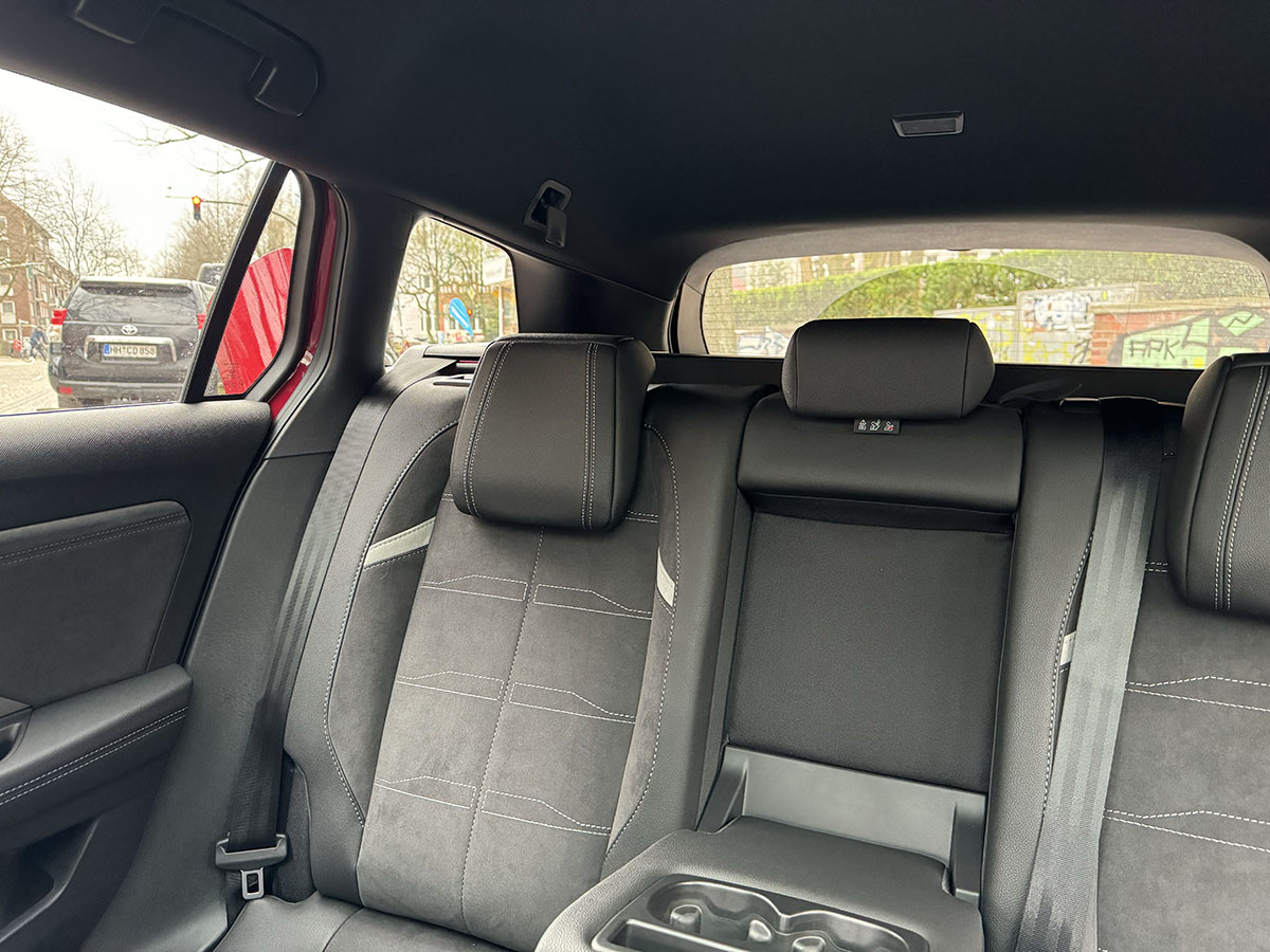 Blick nach hinten durch die Heckscheibe beim E-Auto Opel Astra Electric auf eine städtische Umgebung.