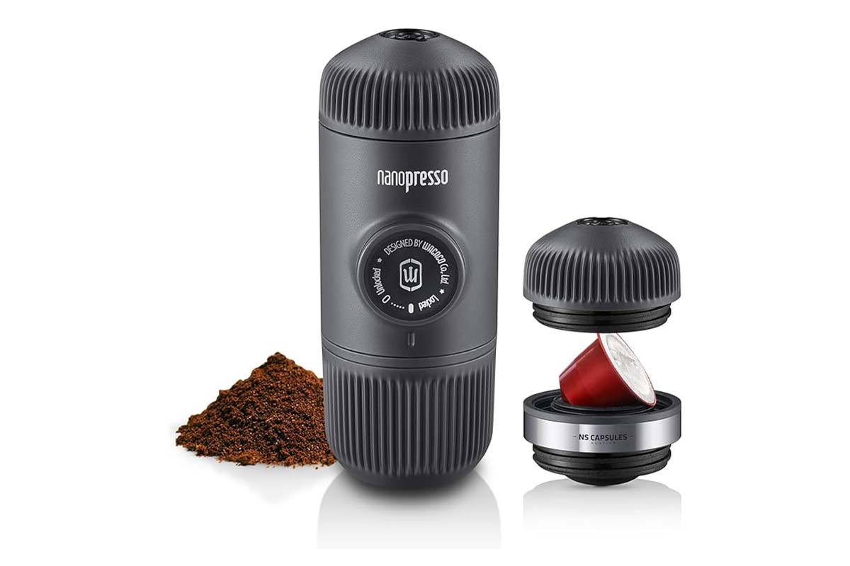Kaffee-Handpresse, daneben Pulver und ein Kapseladapter auf weißem Grund
