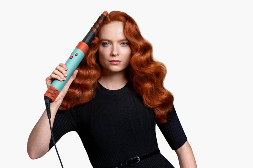 Eine Frau stylt ihre Haare mit dem Dyson Airwrap i.d.