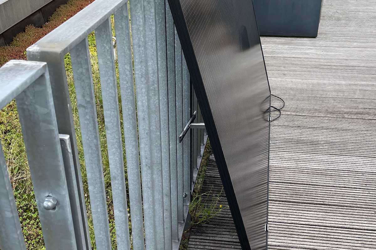 Ein Solarpanel von Kleines Kraftwerk in der Seitenansicht auf einer Dachterrasse.