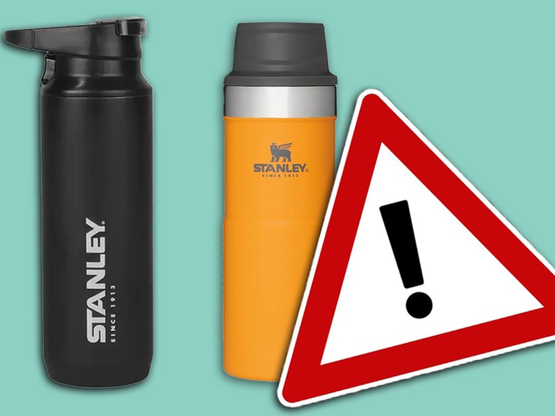 Zwei Stanley-Cups, daneben ein Warnschild vor türkisem Hintergrund.