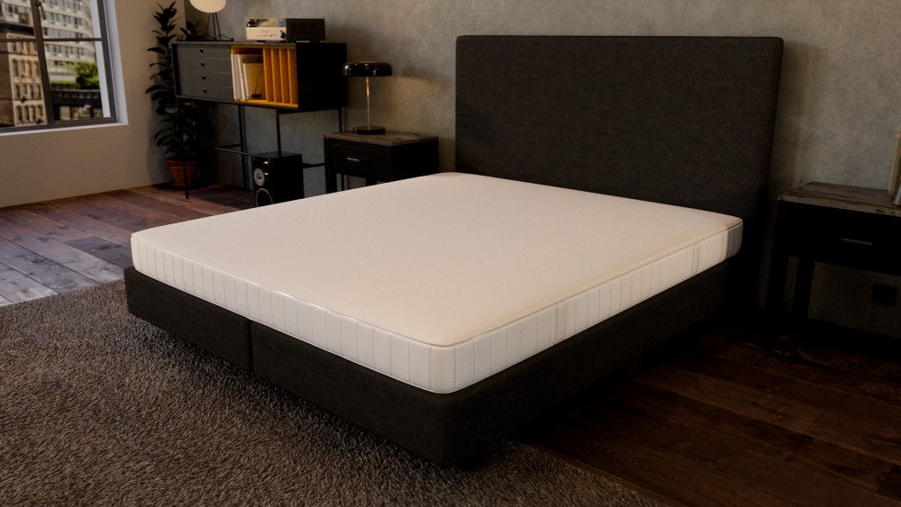 Matratze liegt auf einem Bett. Im Hintergrund ist ein Schlafzimmer erkennbar