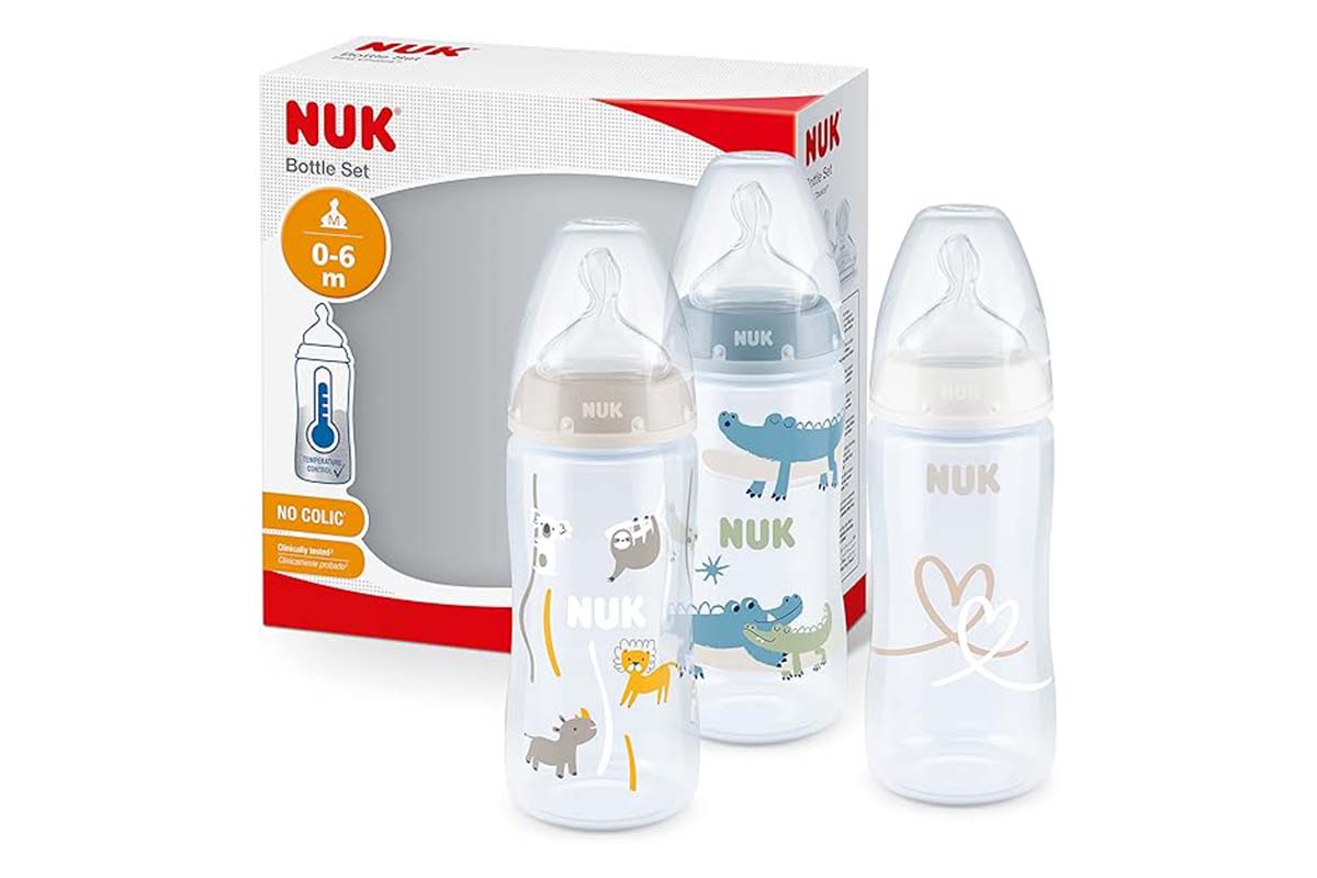 Drei Babyflaschen nebeneinander stehend, dahinter die Verpackung, auf weißem Grund