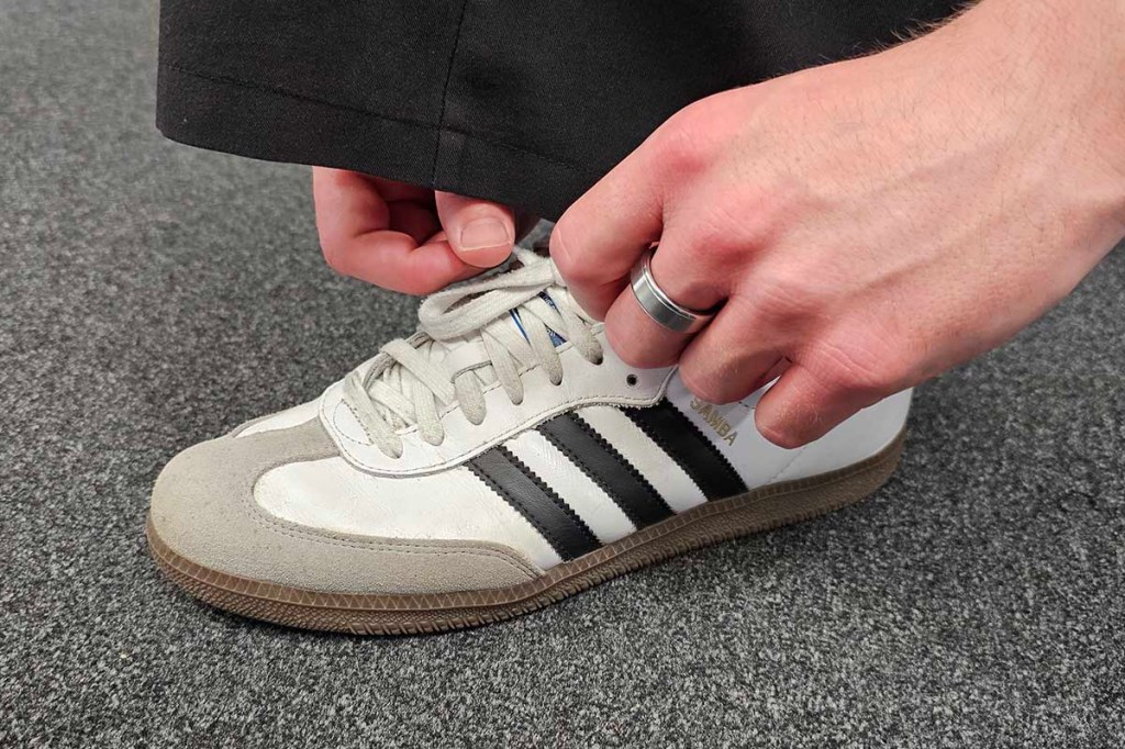 Smart Ring an einer Hand, die einen Sportschuh bindet