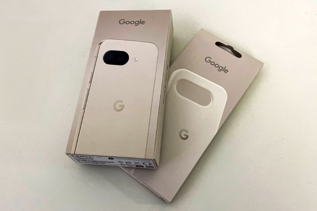 Die Verpackungen des Google Pixel 9a und einer passenden Hülle liegen auf einem weißen Tisch.