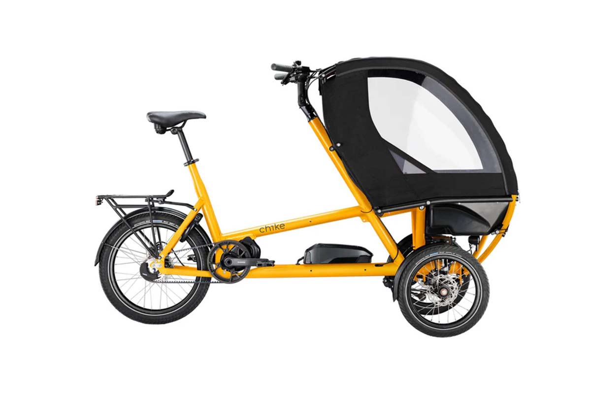 gelbes Cargo-E-Bike mit schwarzer Transportkabine auf weißem Grund