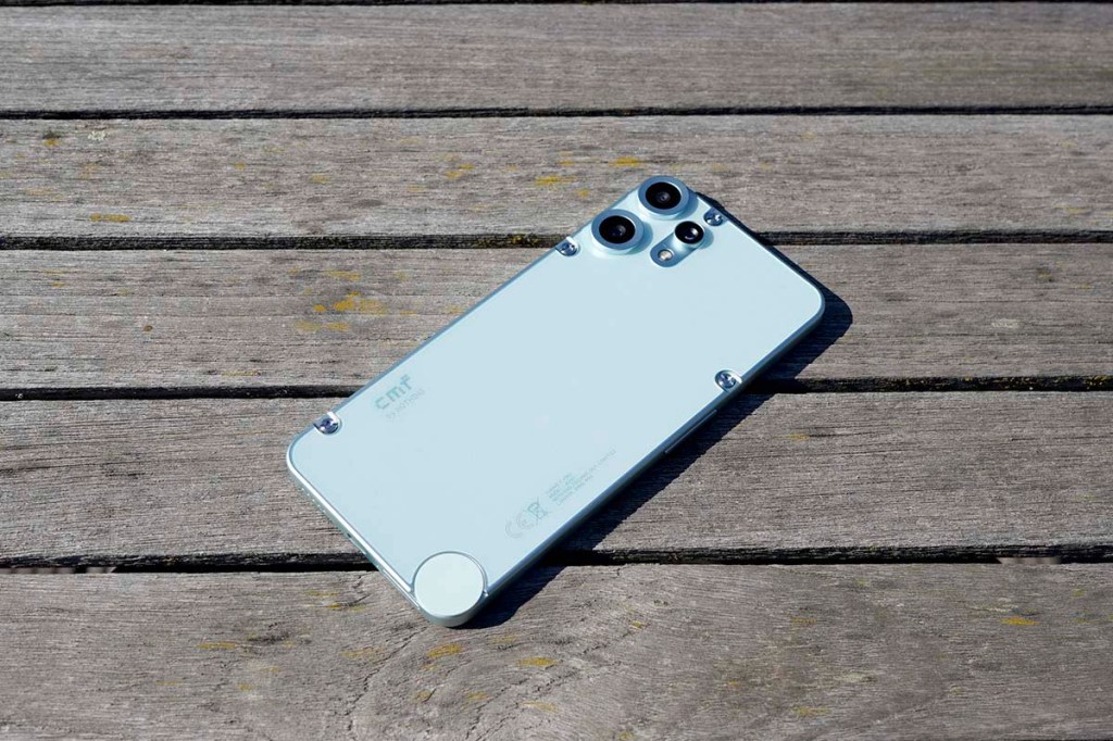 Das CMF Phone 2 Pro liegt mit dem Display nach unten auf einem Holztisch.