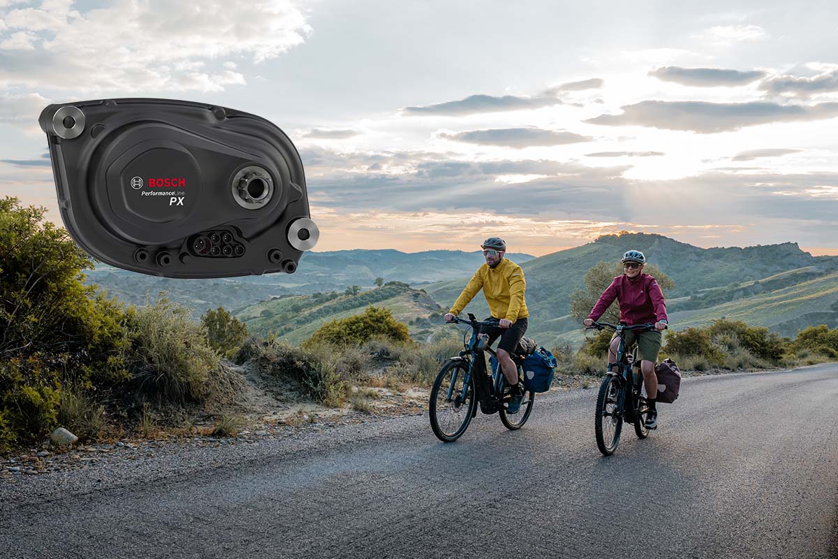 zwei Radfahrer fahren über eine einsame Straße inmitten der Natur, im Bild zudem zu sehen: eine großaufnahme des neuen Bosch-Motors