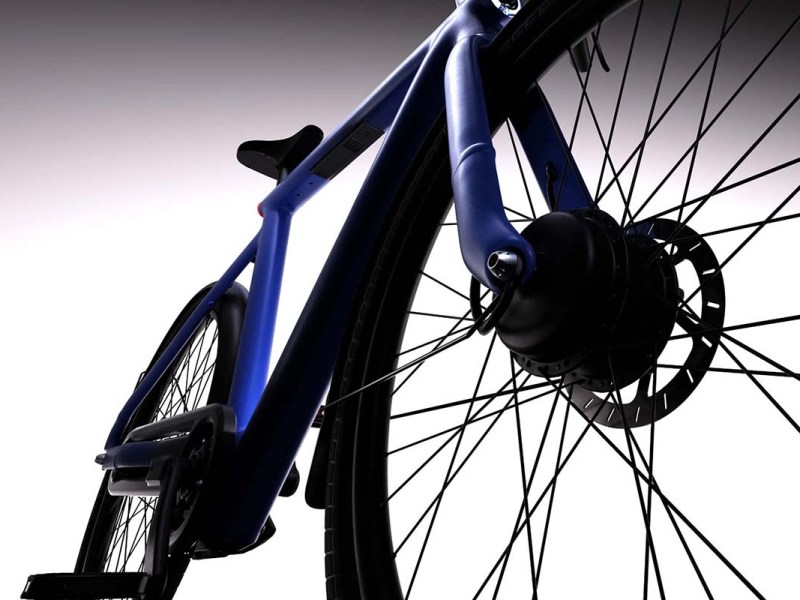 Anschnitt eines blauen E-Bikes aus Froschperspektive, grau-verlaufender Hintergrund