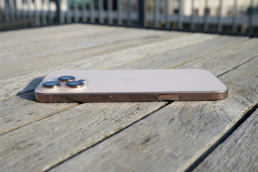 Auf einem Holztisch liegt ein iPhone 16 Pro Max.