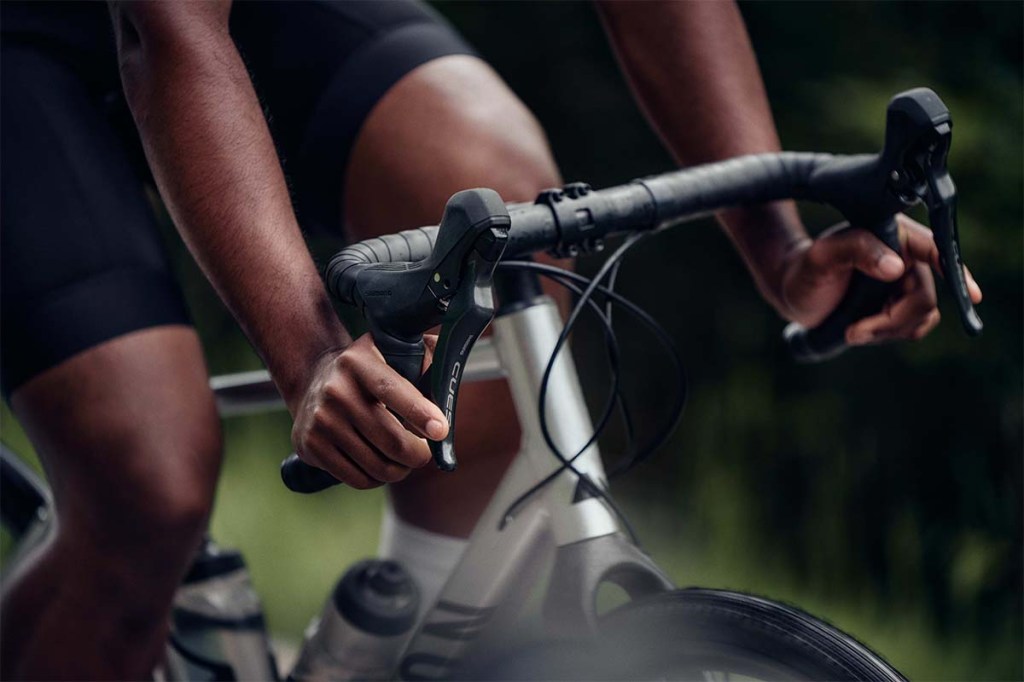 Nahaufnahme eines Dropbar-Fahrradlenkers, eine Person fährt auf dem Fahrrad