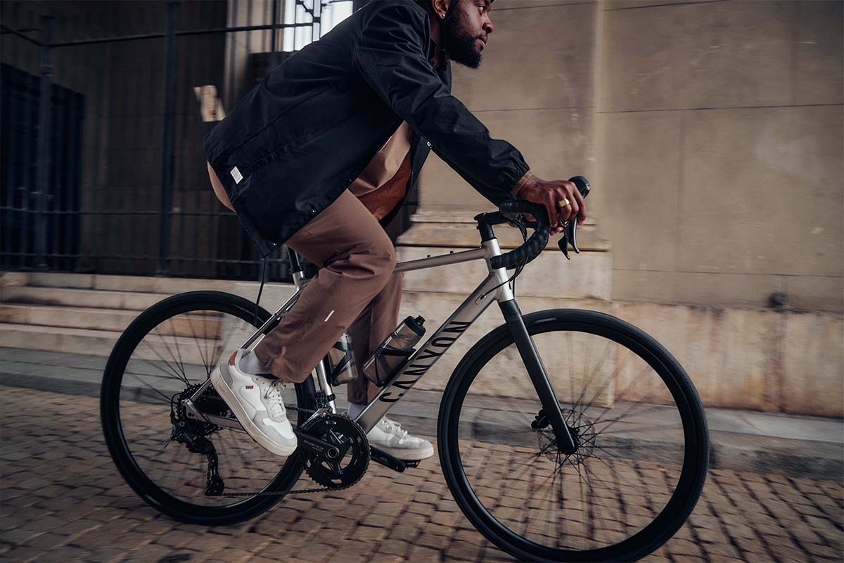 Person auf einem Gravelbike, fährt eine Kopfsteinpflaster-Straße entlang