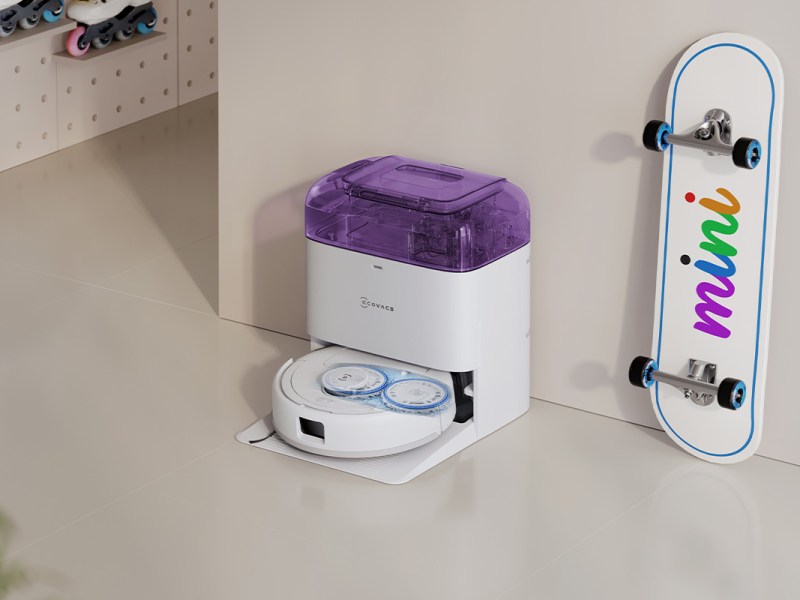 Der Deebot mini in weiß/lila in einer hellen Wohnumgebung mit bunten Akzenten.