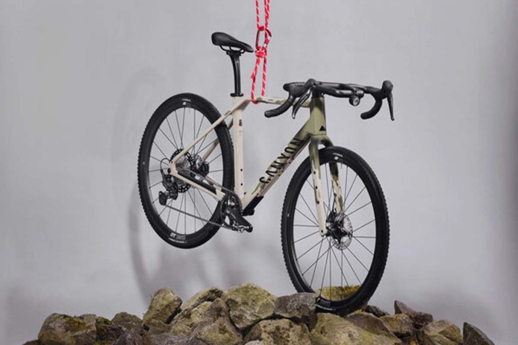 Gravelbike in einem Studio, hängt an einem Seil, unter ihm Steine