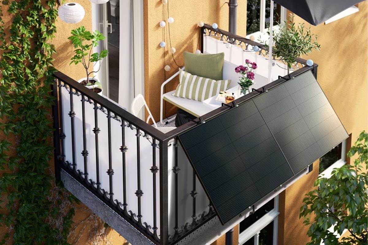 Ein wohnlich dekorierter Balkon mit Solarpanels an einem bunten Haus.