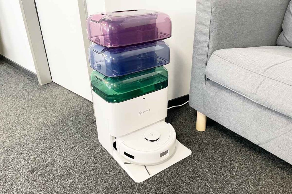 Der Deebot mini von Ecovacs mit drei bunten Wassertanks übereinander in wohnlicher Umgebung