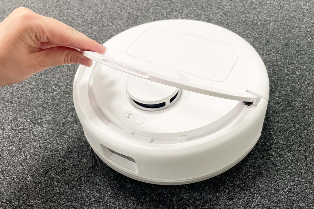 Eine Hand hebt den Tragebügel des Deebot mini hoch.