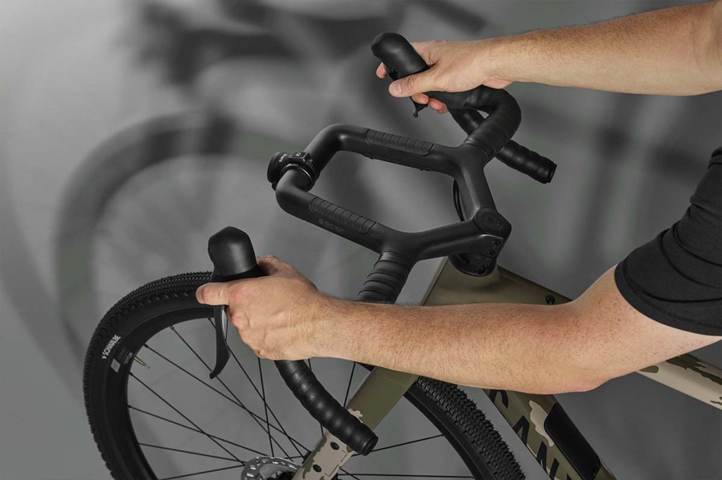 Blick auf einen ungewöhnlichen Fahrradlenker mit vielen Greifoptionen, Hände halten den Lenker fest