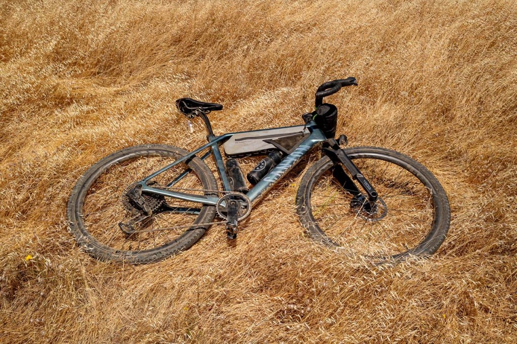 Gravelbike auf von der Sonne verbranntem Gras liegend