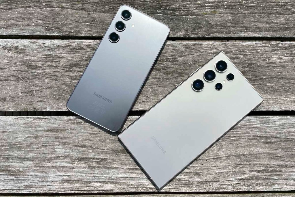 Zwei Samsung Smartphones liegen auf einem verwitterten Holztisch.