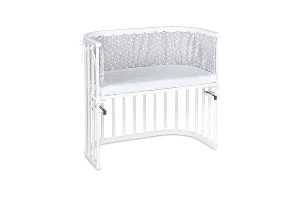 weißes Babybeistellbett auf weißem Grund
