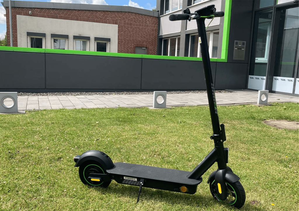 Der Acer-eScooter steht auf einem Rasen.
