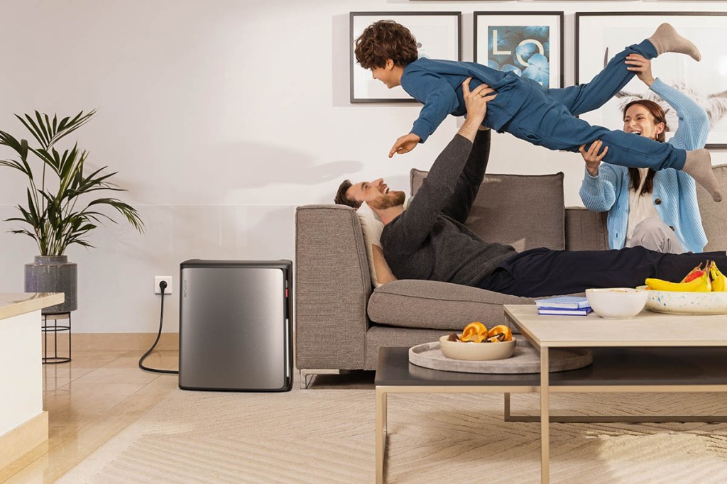 Eine Familie albert im Wohnzimmer, die Stream Ultra X von EcoFlow steht neben dem Sofa