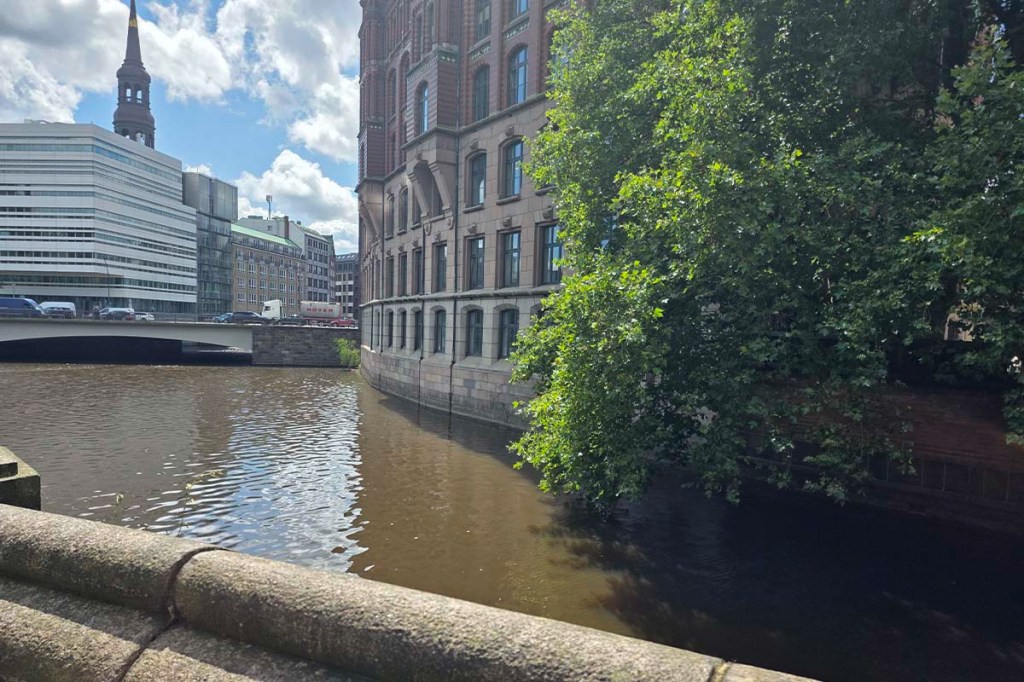 Blick einen Fleet hinunter mit einem Gebäude und eine Baum rechts.